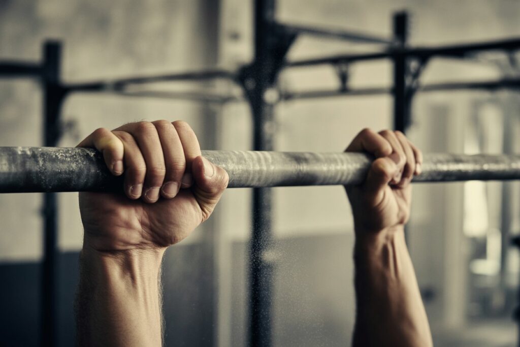 Close-up of hands gripping a pull-up bar representing mental strength discipline and fitness dedication